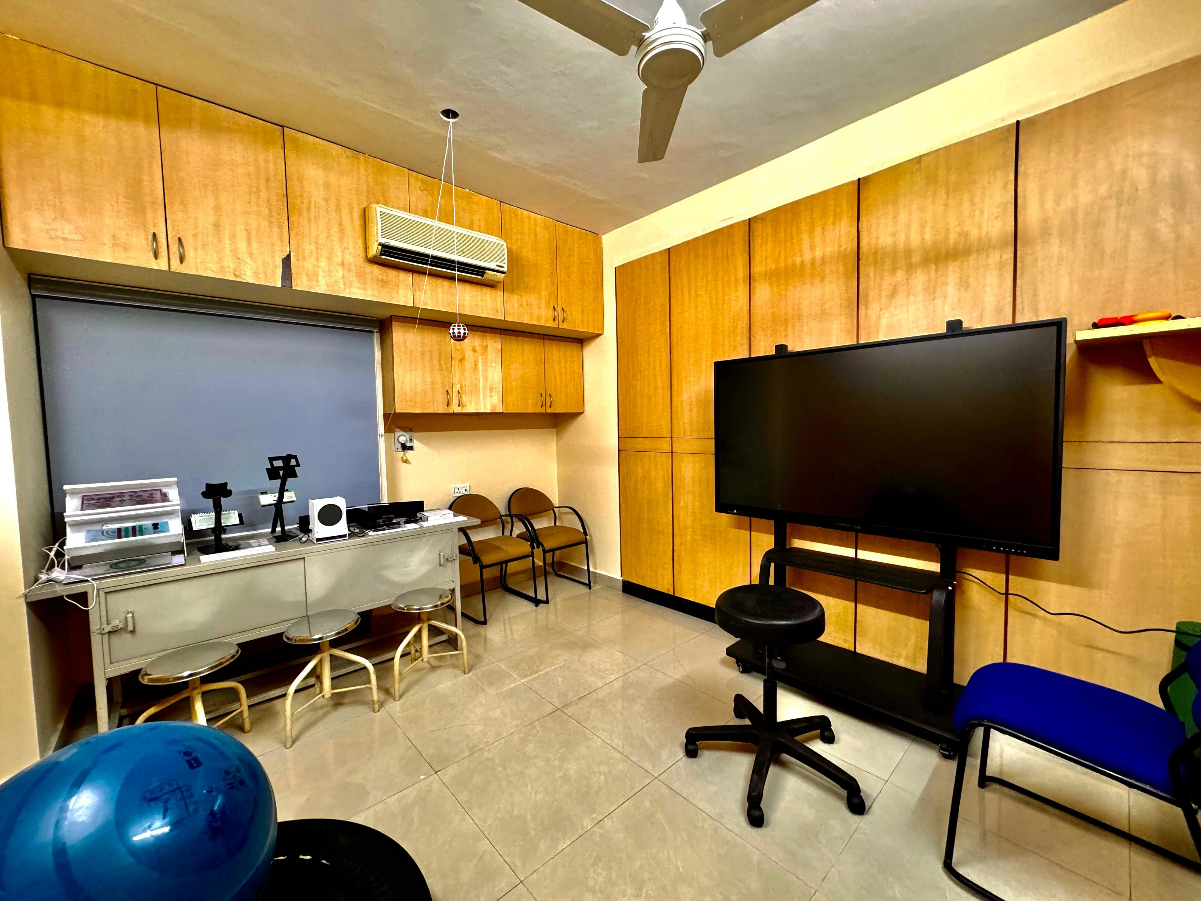 Caring Vision Therapy Anna Nagar Chennai – Vision therapy room with optical instruments, large interactive display screen and therapy equipment